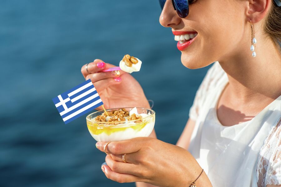 Девушка ест греческий йогурт с медом и орехами 