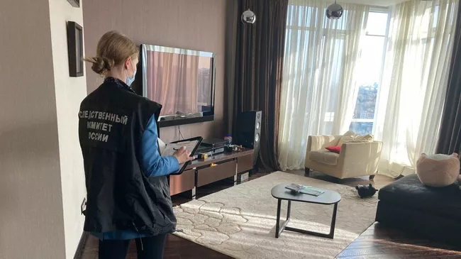 Сотрудница Следственного комитета во время следственных действий в квартире, где произошло тройное убийство