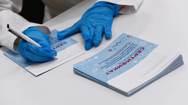 Медицинский сотрудник подписывает сертификат в центре вакцинации 