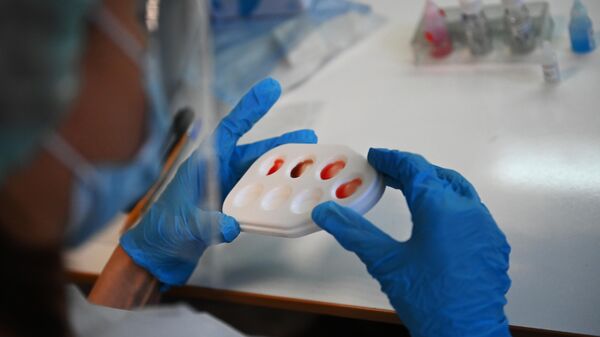 Медицинский сотрудник проводит экспресс-тест крови пациентов, переболевших COVID-19