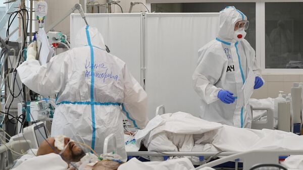 Медики и пациент в резервном госпитале для лечения больных коронавирусом в АТЦ Москва