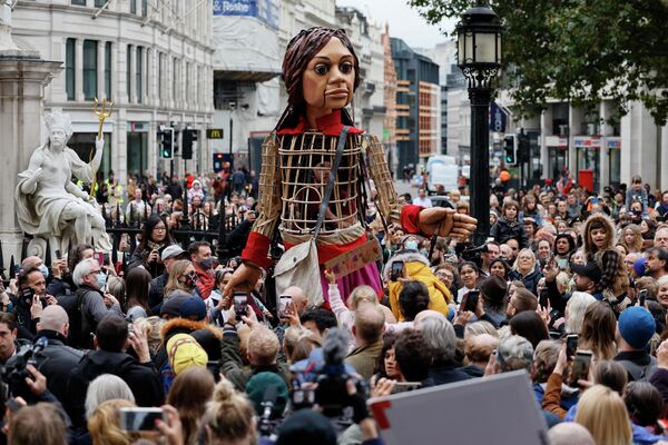 3,5-метровая кукла Маленькая Амаль, которая олицетворяет собой судьбу 9-летнего сирийского ребенка идет по улице Лондона в рамках проекта The Walk