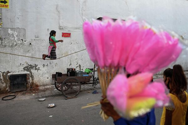 Девочка балансирует на канате во время уличного представления в Нью-Дели 