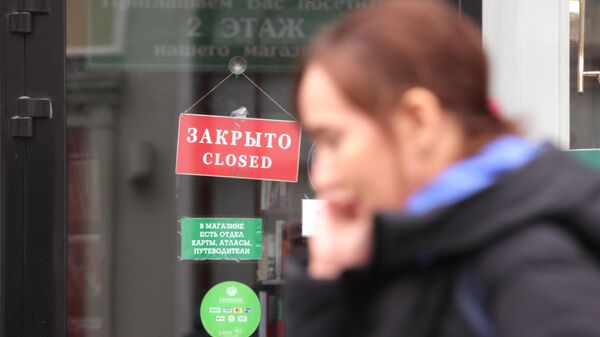 Женщина проходит мимо витрины магазина в Москве