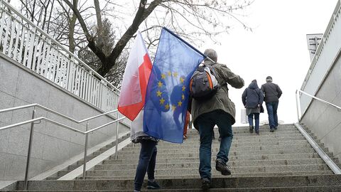 Люди с флагами Польши и ЕС в Варшаве