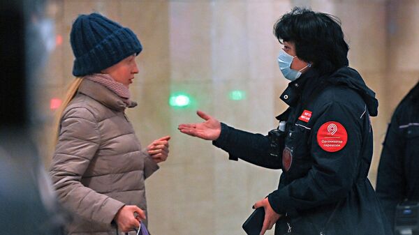 Контролер ГКУ Организатор перевозок беседует с пассажиром без маски на станции метро