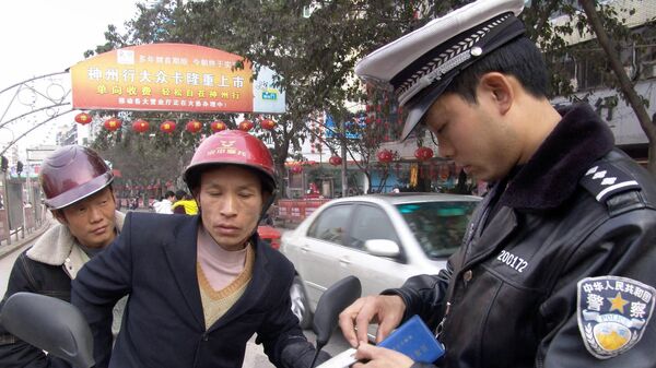 Полицейский проверяет водительские права у водителя в муниципалитете Чунцин в Китае