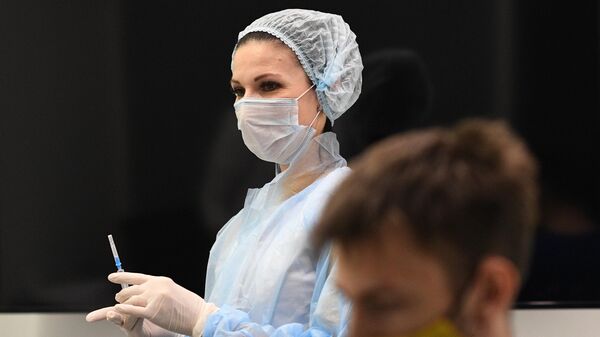 Медицинский сотрудник готовит шприц для проведения вакцинации