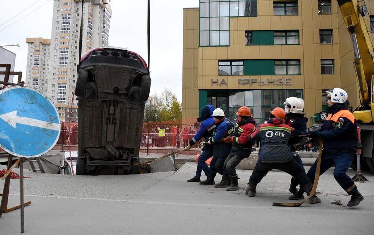 Спасатели муниципальной аварийно-спасательной службы Новосибирска извлекают автомобиль, упавший в провалившийся грунт теплотрассы в Новосибирске