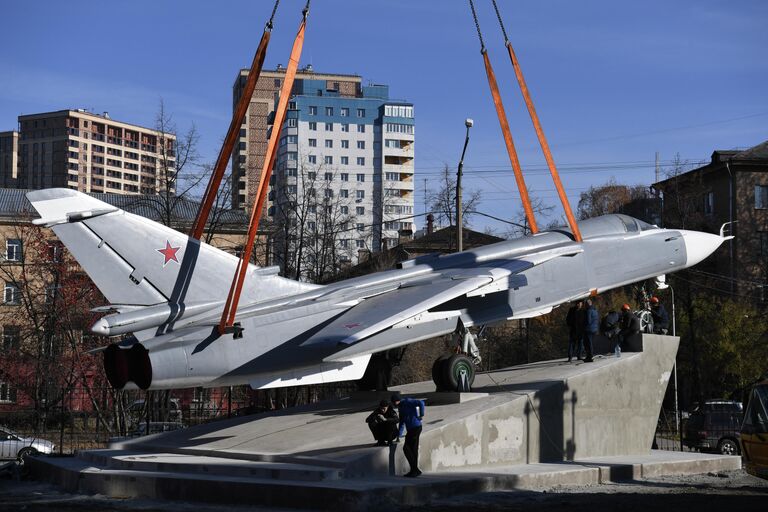 Рабочие устанавливают самолет Су-24 в сквере самолетостроителей на территории НГТУ в Новосибирске