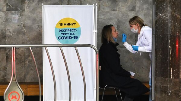 Женщина во время бесплатного экспресс-тестирования на COVID-19 в вестибюле станции московского метрополитена Маяковская