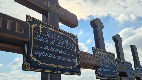 Кресты на месте захоронения в ЛНР жертв конфликта в Донбассе