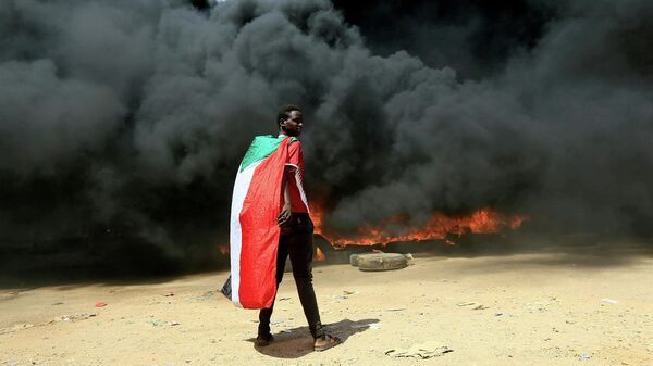 Участник акции протеста на улице в Хартуме, Судан