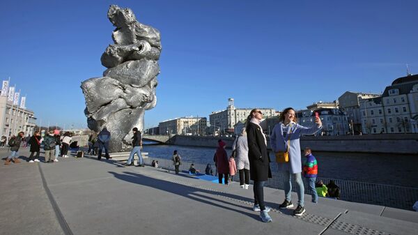 Девушки фотографируются напротив скульптуры Большая глина №4 в центре Москвы