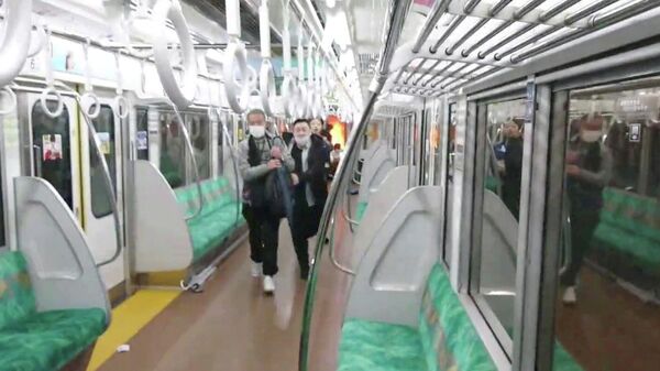 Люди спасаются после нападения человека с ножом в поезде в Токио