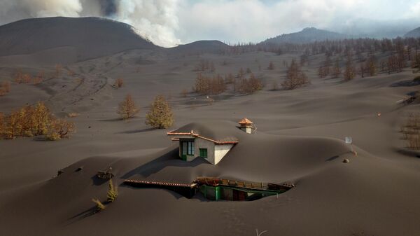 Дом, покрытый пеплом от извержения вулкана, на острове Пальма