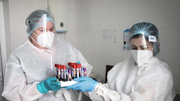Медицинские сотрудники держат пробирки с анализами крови пациентов