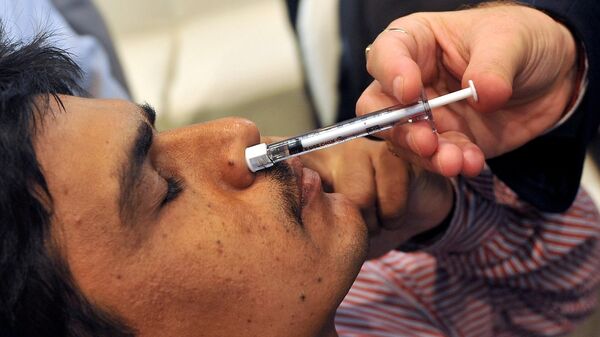 Индийский мужчина получает дозу новой назальной вакцины