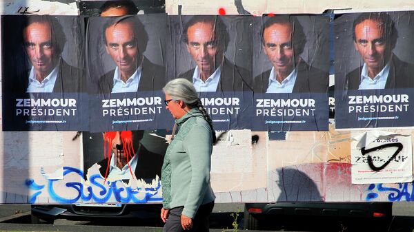 Женщина проходит мимо плакатов с изображением писателя и журналиста Эрика Земмура в Биаррице, юго-западная Франция