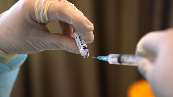 Медицинский работник готовит шприц с вакциной Гам-Ковид-Вак (Спутник V) 