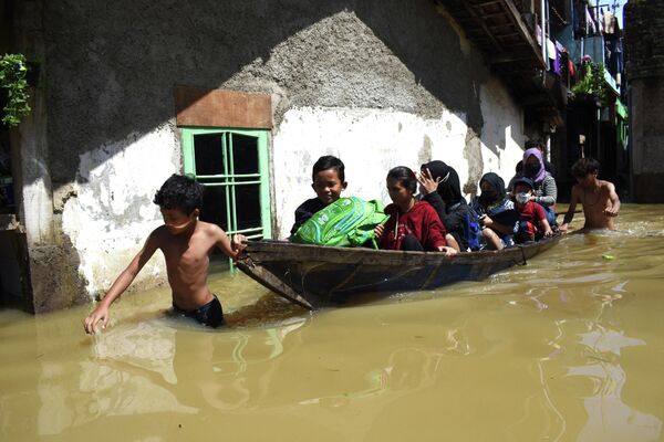 Семья эвакуируется из затопленного дома после сильного дождя в Бандунге, Индонезия