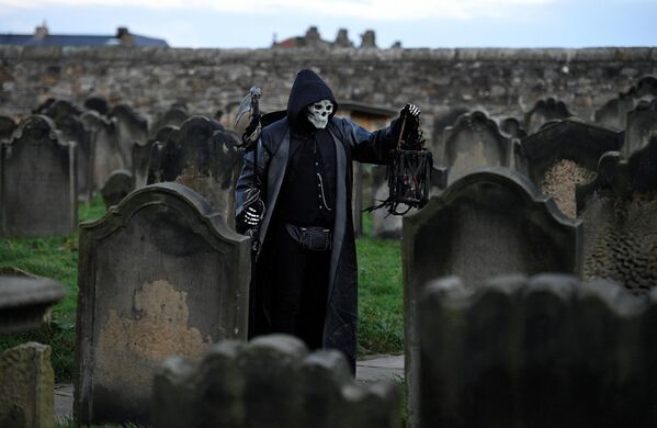Участник фестиваля Whitby Goth Weekend  среди надгробий в церкви Святой Марии в Уитби, северная Англия