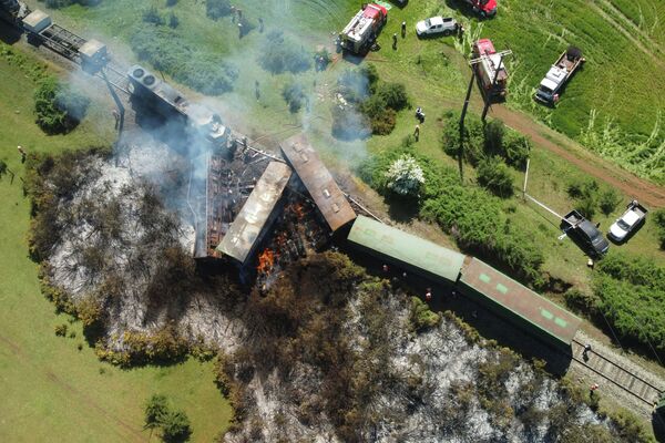 Вид с воздуха на несколько грузовых вагонов и локомотив, которые сошли с рельсов в Виктории, Чили