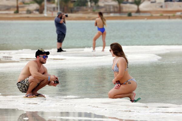 Люди фотографируются на Мертвом море, Израиль
