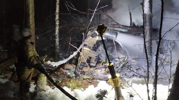 Сотрудники МЧС РФ тушат пожар на месте крушения самолета Ан-12 в Иркутской области