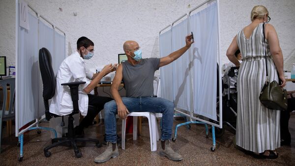 Израильтянин делает селфи во время вакцинации препаратом Pfizer-BioNTech COVID-19 в Рамат-Гане, Израиль