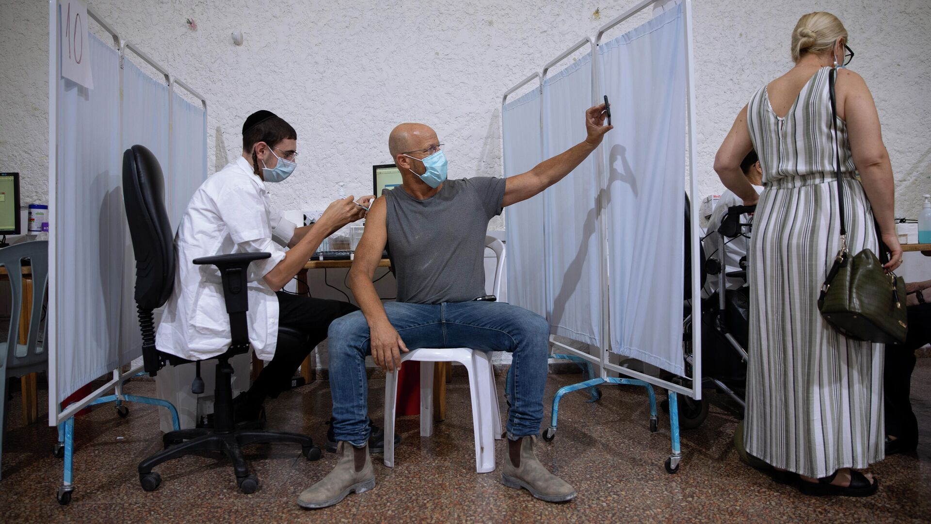 Израильтянин делает селфи во время вакцинации препаратом Pfizer-BioNTech COVID-19 в Рамат-Гане, Израиль - РИА Новости, 1920, 01.12.2021