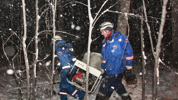 Спасатели несут уцелевший фрагмент самолета Ан-12, потерпевшего крушение в Иркутской области