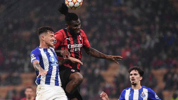 FC Porto's Portuguese midfielder Otavio (L) and AC Milan's Ivorian midfielder Franck Kessie go for a header during the UEFA Champions League Group B football match between AC Milan and Porto on November 3, 2021 at the San Siro stadium in Milan. (Photo by Marco BERTORELLO / AFP)