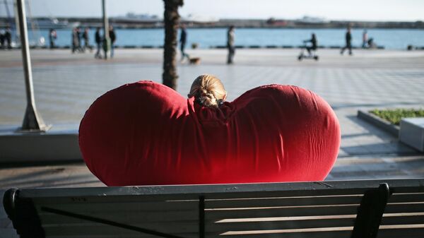 Девушка-промоутер отдыхает на лавочке на набережной Ялты