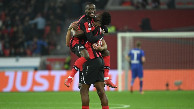 Leverkusen's French forward Moussa Diaby (Up) celebrates with Leverkusen's Burkinabe defender Edmond Tapsoba scoring the 2-0 during the UEFA Europa League Group G football match  Bayer 04 Leverkusen v Real Betis in Leverkusen, western Germany, on November 4, 2021. (Photo by Ina Fassbender / AFP)