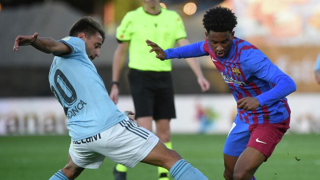 Celta Vigo's Spanish defender Kevin Vazquez  (L) vies with Barcelona's Spanish defender Alejandro Balde during the Spanish league football match between RC Celta de Vigo and FC Barcelona at the Balaidos stadium in Vigo on November 6, 2021. (Photo by MIGUEL RIOPA / AFP)