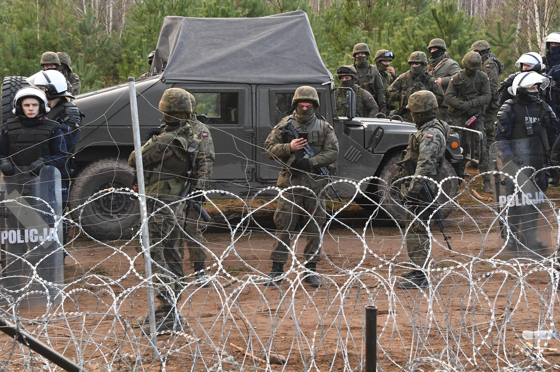 Сотрудники польской полиции и военные у лагеря нелегальных мигрантов на белорусско-польской границе - РИА Новости, 1920, 05.06.2024