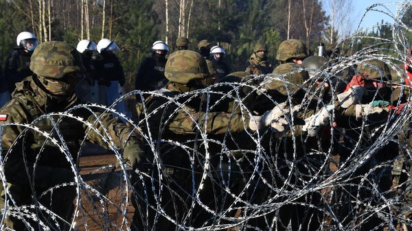 Польские военнослужащие устанавливают забор из колючей проволоки на польско-белорусской границе