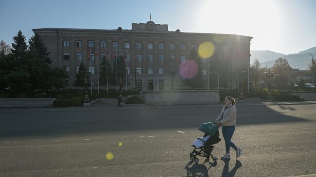 Женщина с коляской у здания правительства в городе Степанакерте в Нагорном Карабахе