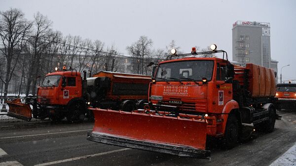 Техника коммунальных служб обрабатывает противоледными реагентами дорогу в Москве