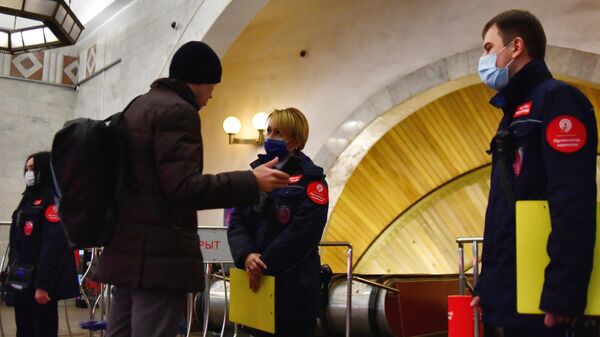 Контролер ГКУ Организатор перевозок беседует с пассажиром без защитной маски на станции метро Цветной бульвар в Москве