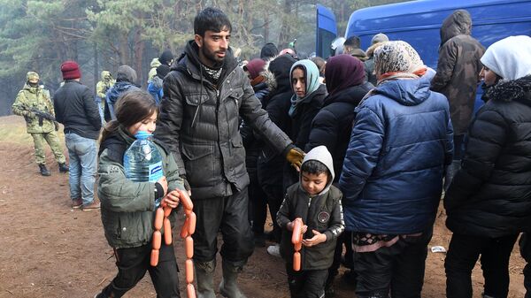 Беженцы во время раздачи гуманитарной помощи сотрудниками Белорусского Красного Креста в лагере нелегальных мигрантов на белорусско-польской границе