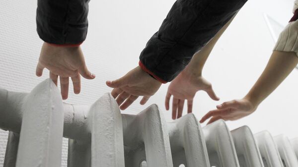 Жители Москвы держат руки над батареей, проверяя, включено ли отопление