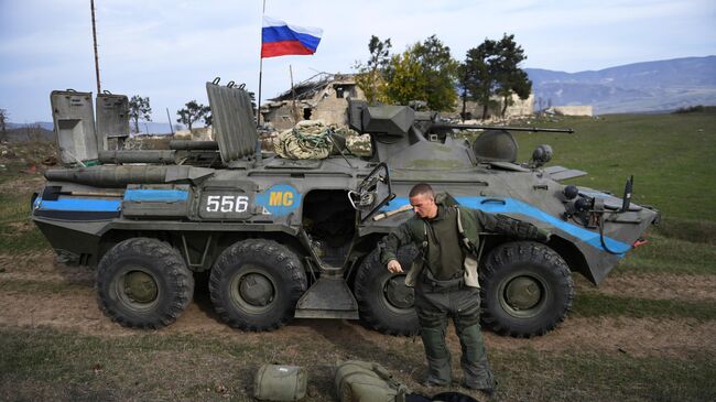 Российский военнослужащий подразделения гуманитарного разминирования у БТР-80 в Нагорном Карабахе