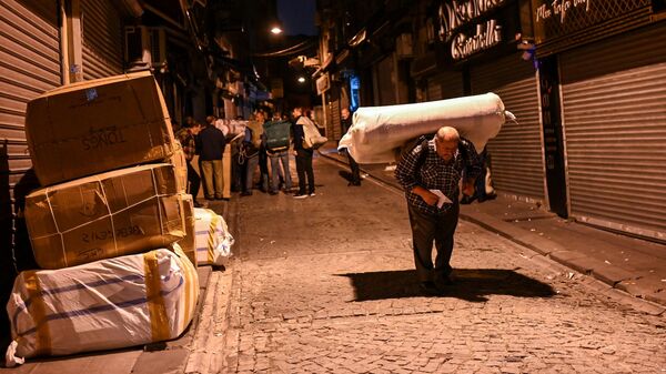 Мужчина несет матрас на спине в Турции 