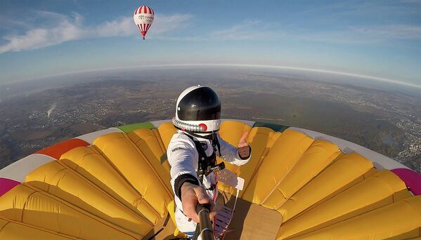 Французский воздухоплаватель Реми Оврард устанавливает новый мировой рекорд, балансируя на куполе воздушного шара на высоте более 4 км