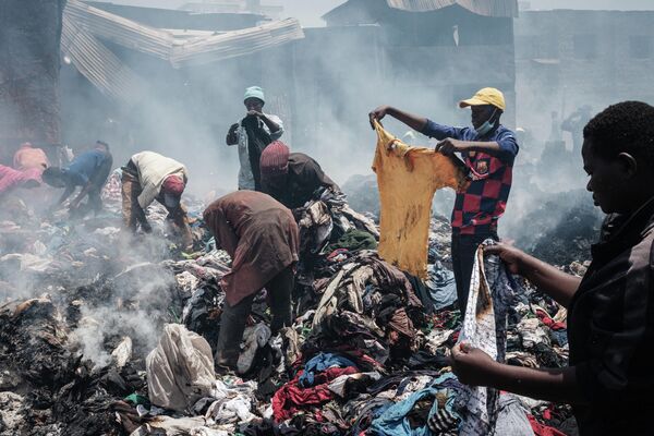 Торговцы собирают одежду после пожара на рынке Гикомба в Восточной Африке, Кения