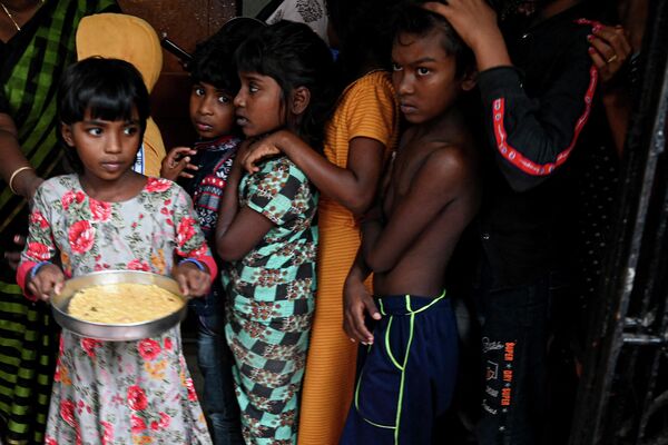 Дети ждут своей очереди на получение еды во временном убежище в Ченнаи 