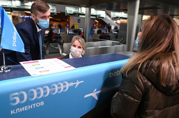 Девушка, ставшая юбилейным, 50-миллионным клиентом авиакомпании Победа с начала полётов, проходит торжественную регистрацию в аэропорту Внуково в Москве