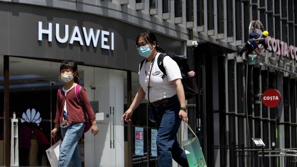 Люди проходят мимо магазина Huawei в Пекине 